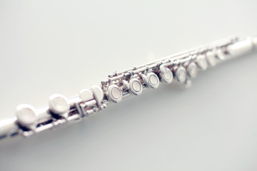 A part of a silver flute on white