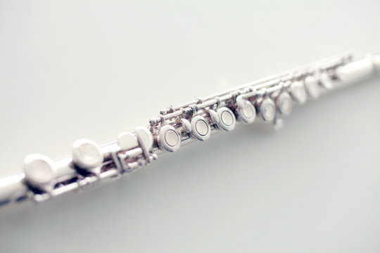 A part of a silver flute on white