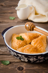 Homemade baklava stuffed cream with honey sirup on wooden table. Eastern sweets. Ramadan food