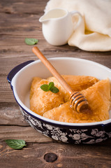 Homemade baklava stuffed cream with honey sirup on wooden table. Eastern sweets. Ramadan food