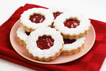 Raspberry Filled Linzer Torte Cookies on Plate and White Background