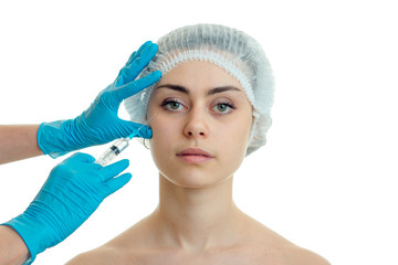 young girl without makeup in a special cap for hair at a cosmetologist in blue gloves