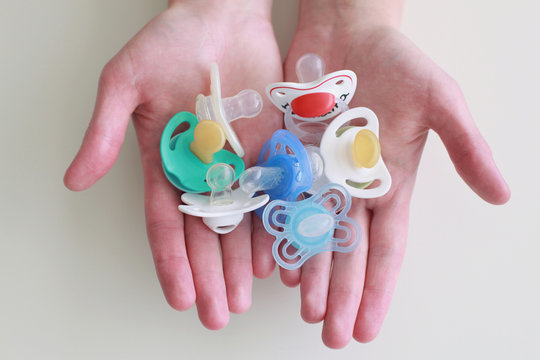 Baby pacifiers in hands