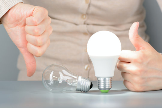 The woman shows a like and dislike incandescent and led light bulbs