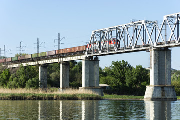 A freight train goes over the bridge across the bridge.