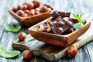 Chocolate with hazelnuts in a wooden bowl.