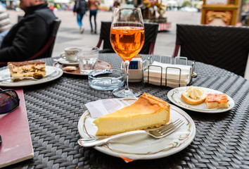 Spritz Aperol drink with traditional snacks cicchetti, ricotta cheesecake and tiramisu in Italian cafe. Traditioanal italian dessert. Image with small depth of field