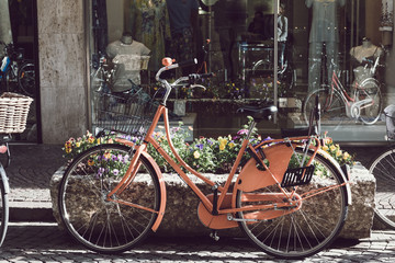 Retro vintage orange bike on cobblestone street in the old town. Old charming bicycle concept.