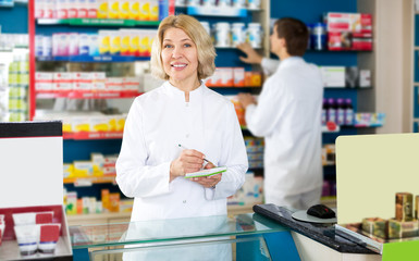 Fototapeta na wymiar Pharmacist and pharmacy technician posing in drugstore