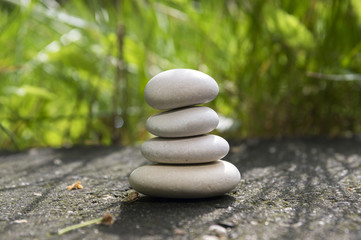 Fototapeta na wymiar Harmony and balance, simple pebbles tower in the grass, simplicity, four stones