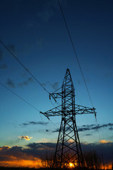 Power lines against the sky at sunset