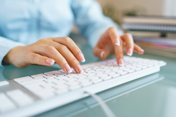 Fototapeta na wymiar Woman office worker typing on the keyboard