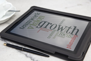 tablet with growth concept word cloud