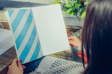 Beautiful woman looking at menu and ordering foods in restaurant