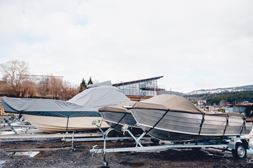 Row of boats in storage for the winter under the awning. Warehouse on the boat pier. Concept preparation for winter.