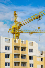 construction cranes, near the house under construction in sunny day