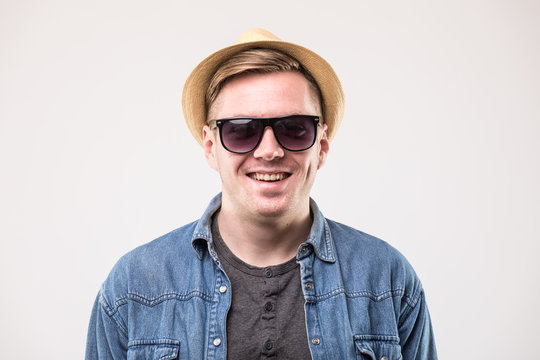 Portrait of attractive young man in hat and sunglasses over white background