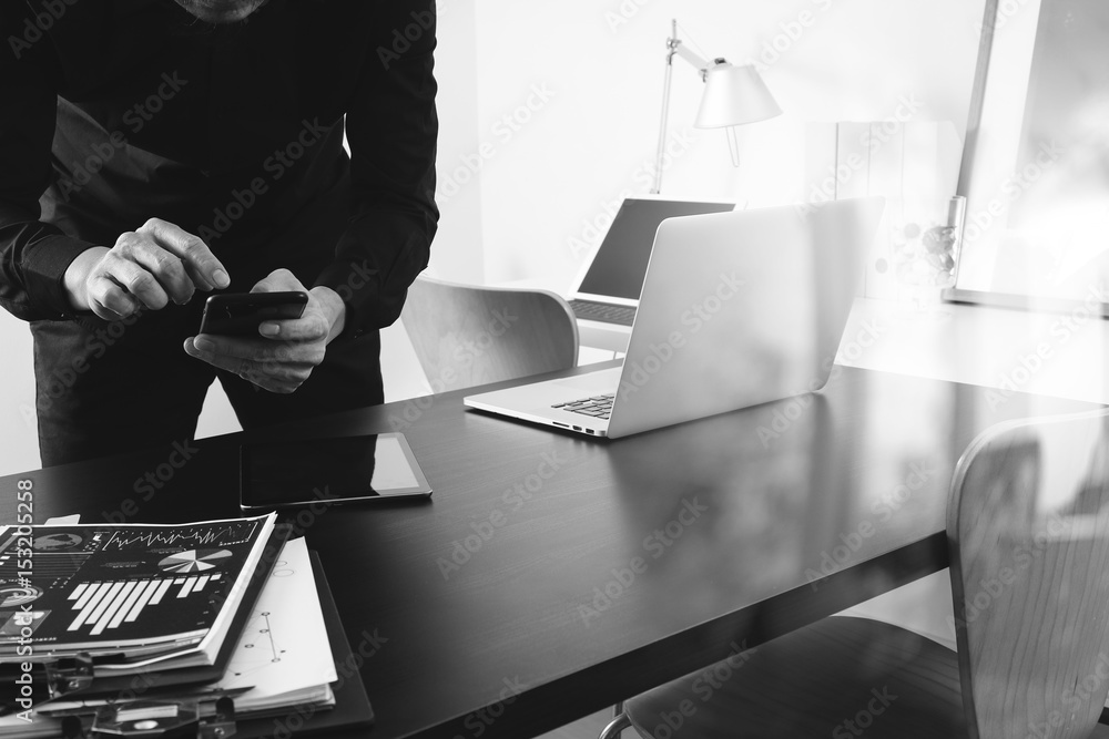 Poster businessman or Designer using smart phone with latop and digital tablet computer and document on desk in modern office,black and white