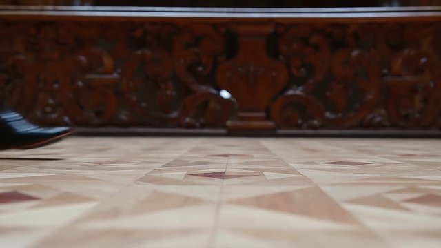 Man in black leather brogues walking on the parquet