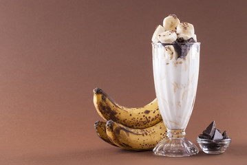 Milkshake with banana and chocolate on a brown background