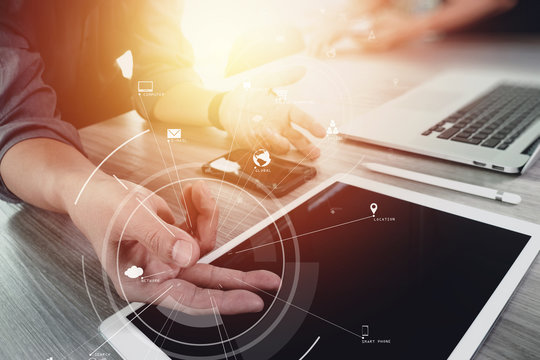 creative working with mobile phone and digital tablet and laptop computer on wooden desk in modern office with virtual icon diagram
