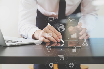 businessman working with mobile phone and digital tablet and laptop computer on wooden desk in modern office with virtual icon diagram