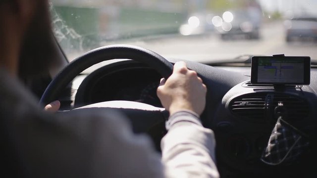 Man rides a car with a navigator on a smartphone