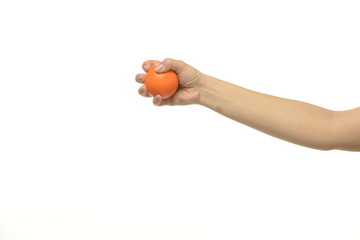 The hand holds an orange round object