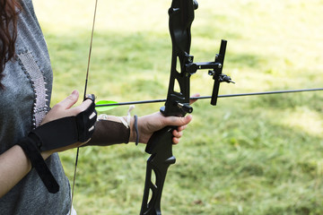 Female archer holding bow and arrow, getting ready to aim