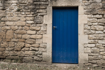 Blue wooden door on a grey stone wall