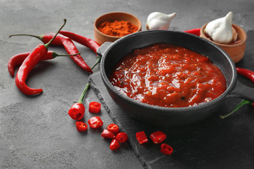 Composition with tasty chili sauce on grey textured table