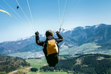 Foto auf Acrylglas Luftsport Paraglider ist auf den Gleitschirmriemen - soaring Flugmoment