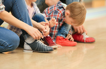 Family changing shoes in bowling club