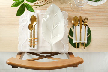 Table setting with white color napkin and floral decor on wooden surface
