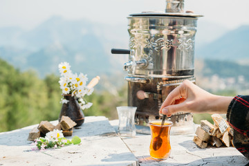 Fototapeta premium Hand holding spoon and tulip-shaped tea glass
