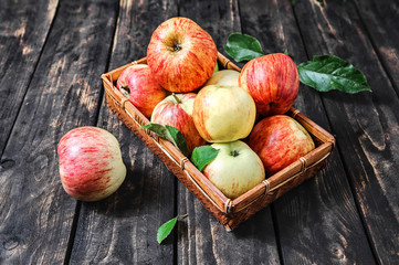 apples in a basket on the wooden background