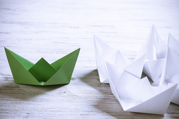 Business leadership concept with white and color paper boats on 