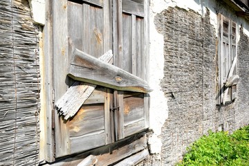 Window of an old wooden abandoned house demolishing in the wilderness