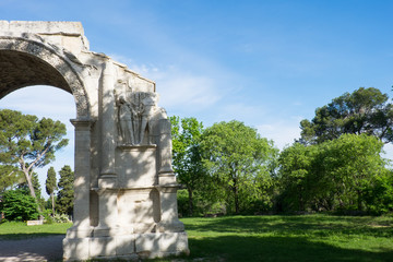 Fototapeta na wymiar France, Saint Remy de Provence in Southern France, Glanum, The triumphal arch of Glanum (10-25 BC) 1921.Mausoleum of the Julii (about 40 BCE), in background.