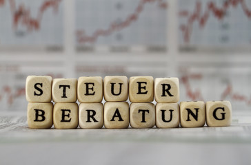 Steuerberatung mit Buchstabenwürfeln auf eine Zeitung gebaut