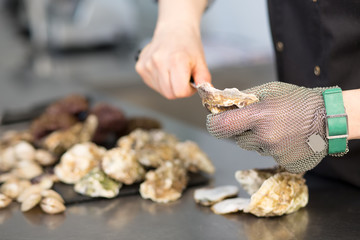 Chef cook cuts sea hedgehog using chain glove in the kitchen of restaurant