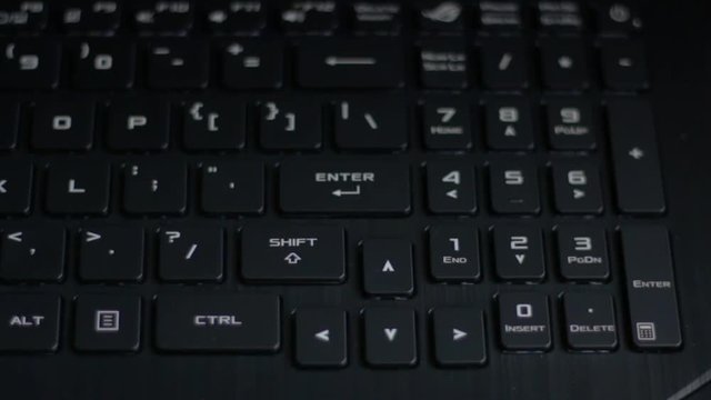 Enter in the center. Overhead view of backlit black modern pc laptop keyboard with white characters