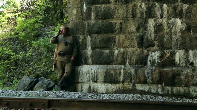 Actor dressed in military uniforms. Soldiers of the Soviet army smokes. The army of the USSR. A soldier with a rifle guarding a railway tunnel.