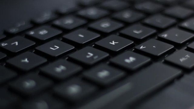 Angled close up of pulsing back lit laptop keyboard with red nahimic RGB keys flashing side to side
