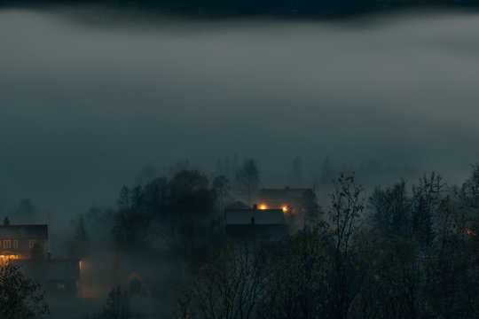 houses disappearing in fog at dawn