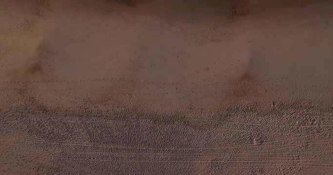 A unique aerial top-down view of the early morning ocean surf hitting against a sandy beach.  	