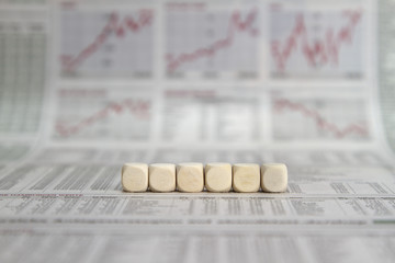 a row of six blank cubes on a business newspaper background