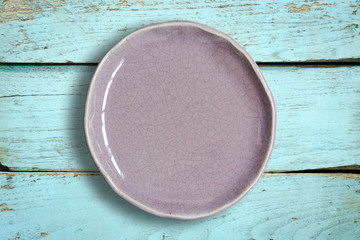 Top view of blank white dish on a wood background.