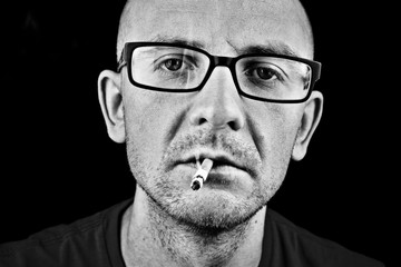 Man smoking cigarette in glasses