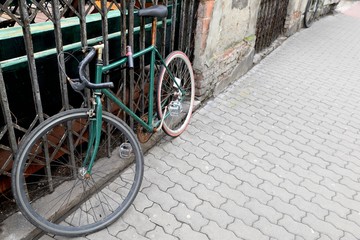 Old rusty cycling bike pinned to the fence